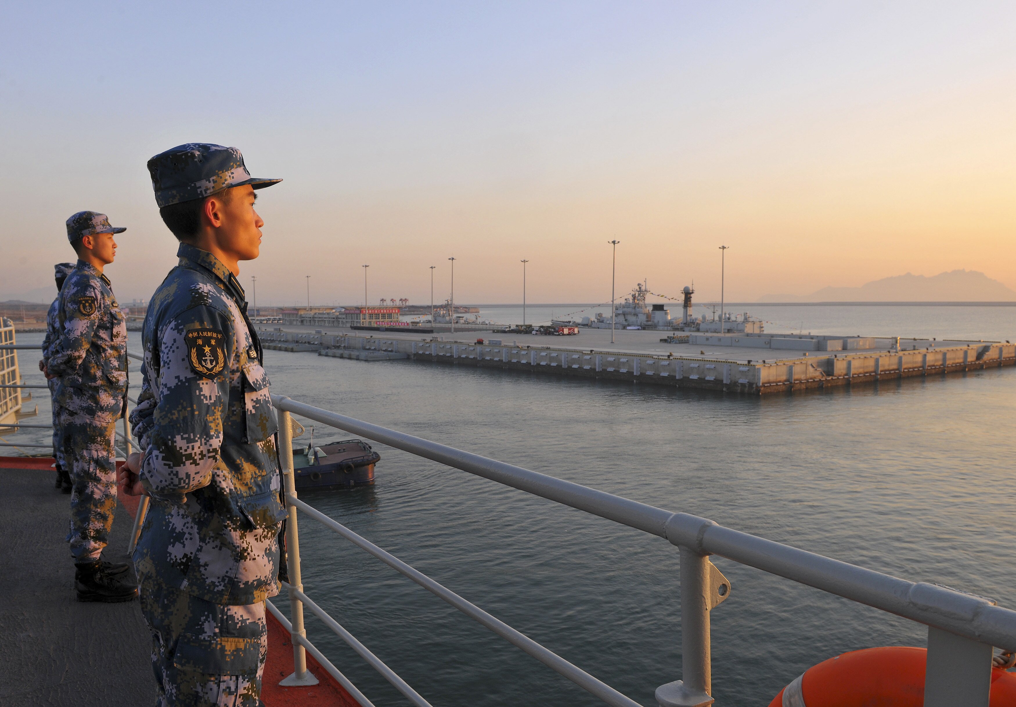 Chinese naval soldiers stand guard on China's first aircraft carrier Liaoning, as it travels towards a military base in Sanya, Hainan province, in this undated picture made available on November 30, 2013. (Stringer/Reuters)